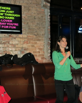 Woman holding a microphone and passionately singing karaoke