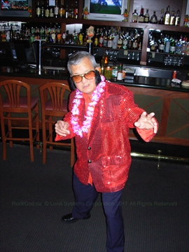 Peter 'Pelvis' performing live on stage at a festive Christmas Karaoke event