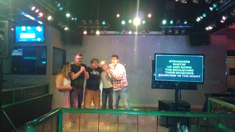 Crowd gathered around, cheering and singing karaoke collectively